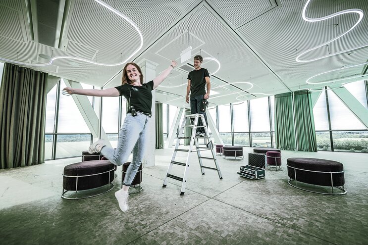 Young woman jumps into the air, next to her a young man on a ladder | © MUNK GmbH