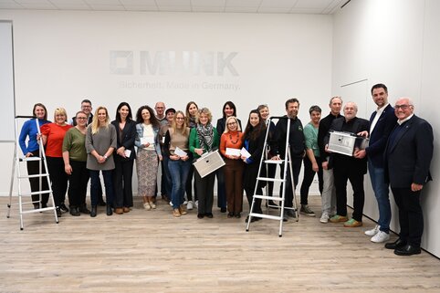 Die Geschäftsleitung der MUNK Group, die Mitglieder des Familienbeirats der MUNK Group und Lehrkräfte aus Günzburger und Leipheimer Schulen stehen für ein Gruppenfoto zusammen.