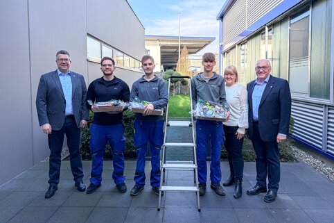 Alexander Werdich, Ferdinand Munk und Margit Werdich-Munk gratulieren den drei Auszubildenen zu ihrer bestandenen Gesellenprüfung und stehen für ein gemeinsamen Foto in einem Halbkreis zusammen. | © MUNK GmbH