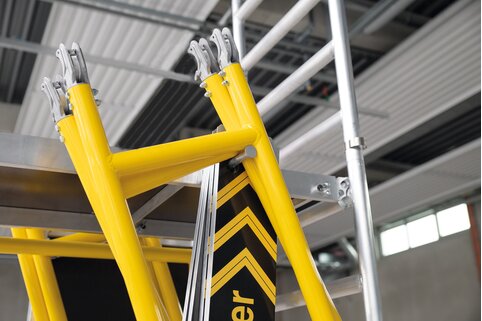 Die leichten Einzelbauteile des FlexxTower werden an ausziehbaren Einhängekonsolen der Plattform eingehängt und so einfach von Ebene zu Ebene mitgenommen.  | © MUNK GmbH