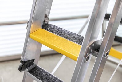 On request, the multi-purpose ladder with steps is also available with slip-resistant clip-step R13 step padding. The lowest steps of each section of ladder on this model also feature yellow step padding for even greater signal effect and safety.  | © MUNK GmbH