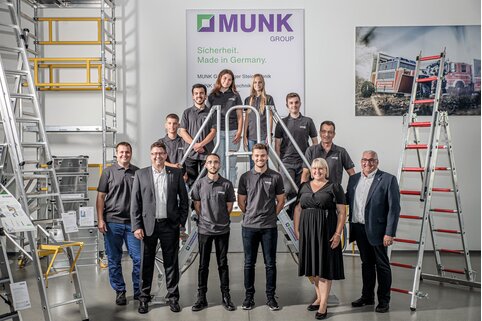 Le propriétaire et directeur Ferdinand Munk (devant à droite), la responsable du personnel Margit Werdich-Munk (2ème à partir de la droite) ainsi que le directeur Alexander Werdich (2ème à partir de la gauche) et les responsables de la formation des métiers industriels Ernst Schlosser (à gauche) et Thomas Schroweg (2ème rangée à droite) avec les sept starters professionnels au centre de conseil du Munk Group. | © MUNK GmbH