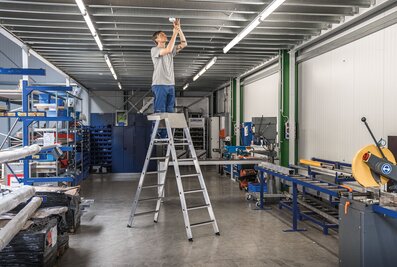 Volle Sicherheit bei der Arbeit bietet die neu entwickelte TRBS-konforme Sicherheits-Stufen-Stehleiter mit integrierter Stützblende an den beiden obersten Stufen. | © MUNK GmbH