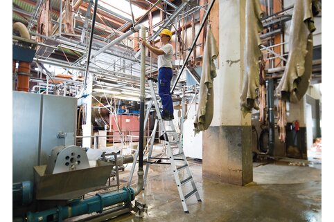 Le marchepied antidérapant clip-step R13 de Munk Günzburger Steigtechnik offre une bonne stabilité sur l'échelle, même dans les zones de travail humides. | © MUNK GmbH