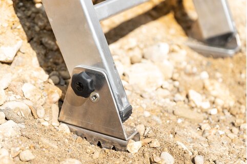 L'articulation mobile à griffes au sol permet à l'échelle d'excavation à marches de reposer sur toute sa surface sur le sol et assure une stabilité sûre avec un angle d'inclinaison correct. | © MUNK GmbH