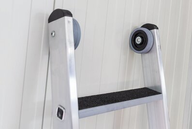 L'échelle supérieure de la nouvelle échelle coulissante à corde à marches de Munk Günzburger Steigtechnik est équipée de roulettes murales, ce qui permet de protéger les surfaces murales ou de façade lors de la montée. | © MUNK GmbH