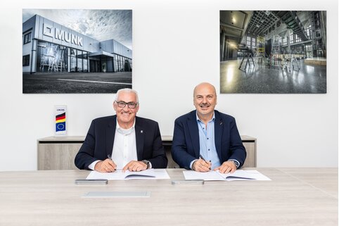 Schwarz auf Weiß: Ferdinand Munk (links) und Massimo Grossele unterzeichnen am Stammsitz der Munk Group in Günzburg die exklusive FlexxLift-Partnerschaft. | © MUNK GmbH
