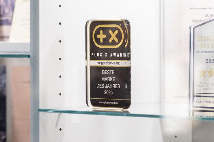 Gläserner Award "Beste Marke des Jahres" steht in der Vitrine neben anderen Preisen und Auszeichnungen der MUNK Group. | © MUNK GmbH