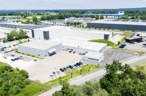 Aerial view of MUNK Group Plant 4 in Lochfelbenstraße, Günzburg: production halls and parking areas, home of the configurator team and manufacturing site for products planned with the online configurator such as stairs, crossovers and vertical ladders. | © MUNK GmbH